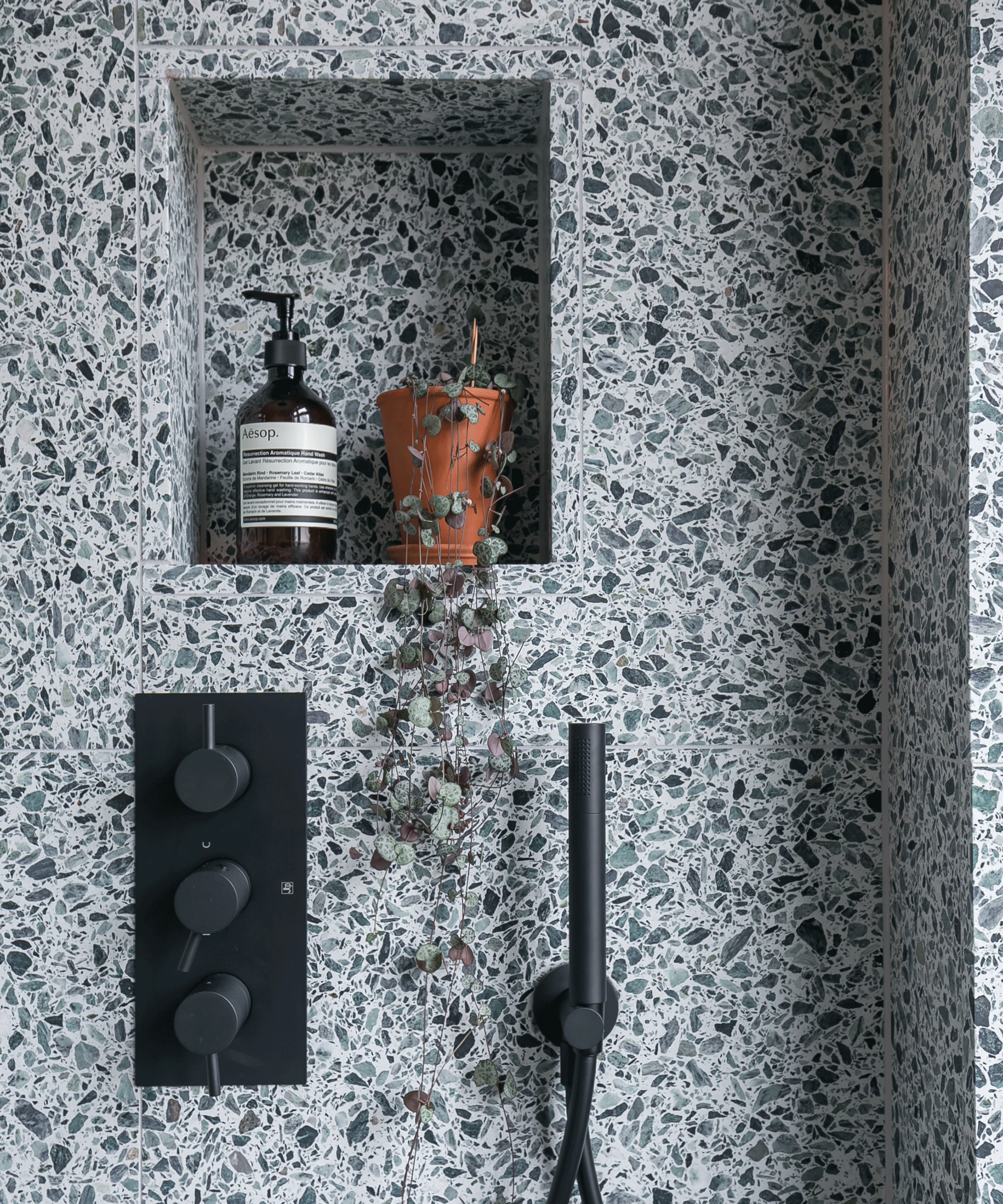 Terrazzo shower with storage nook