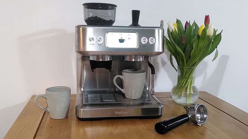 ProCook Barista Bean to Cup Espresso Coffee Machine on a table with two mugs and a vase of flowers