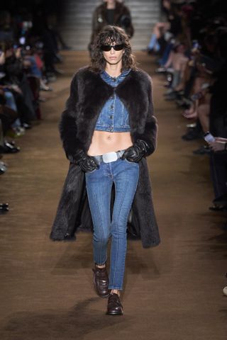 Miu Miu Fall 2024 show. A woman wearing skinny jeans with loafers.