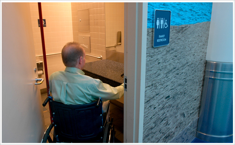 sign says family restroom, man entering