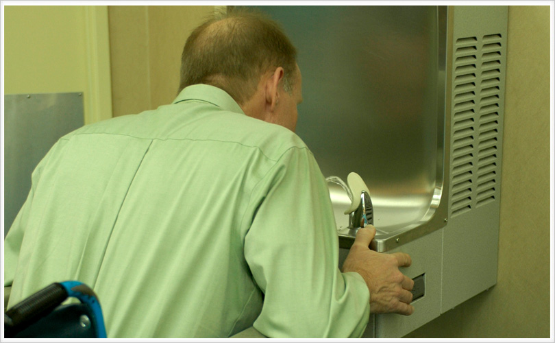 man using wheelchair accessing the drinking fountain