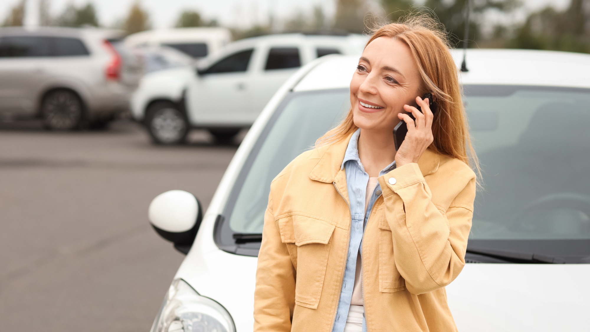 woman on phone by parked car