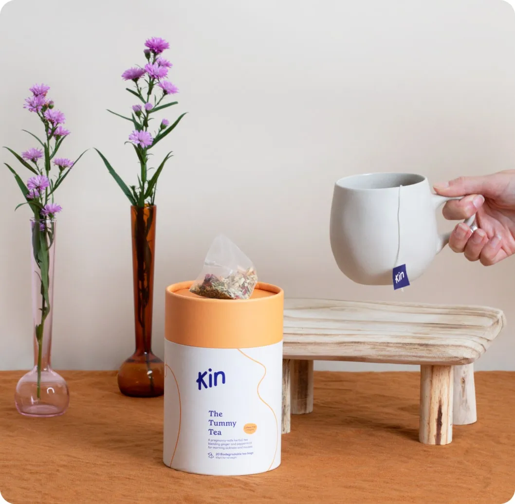 the tummy tea jar with hand holding a cup and tea bag