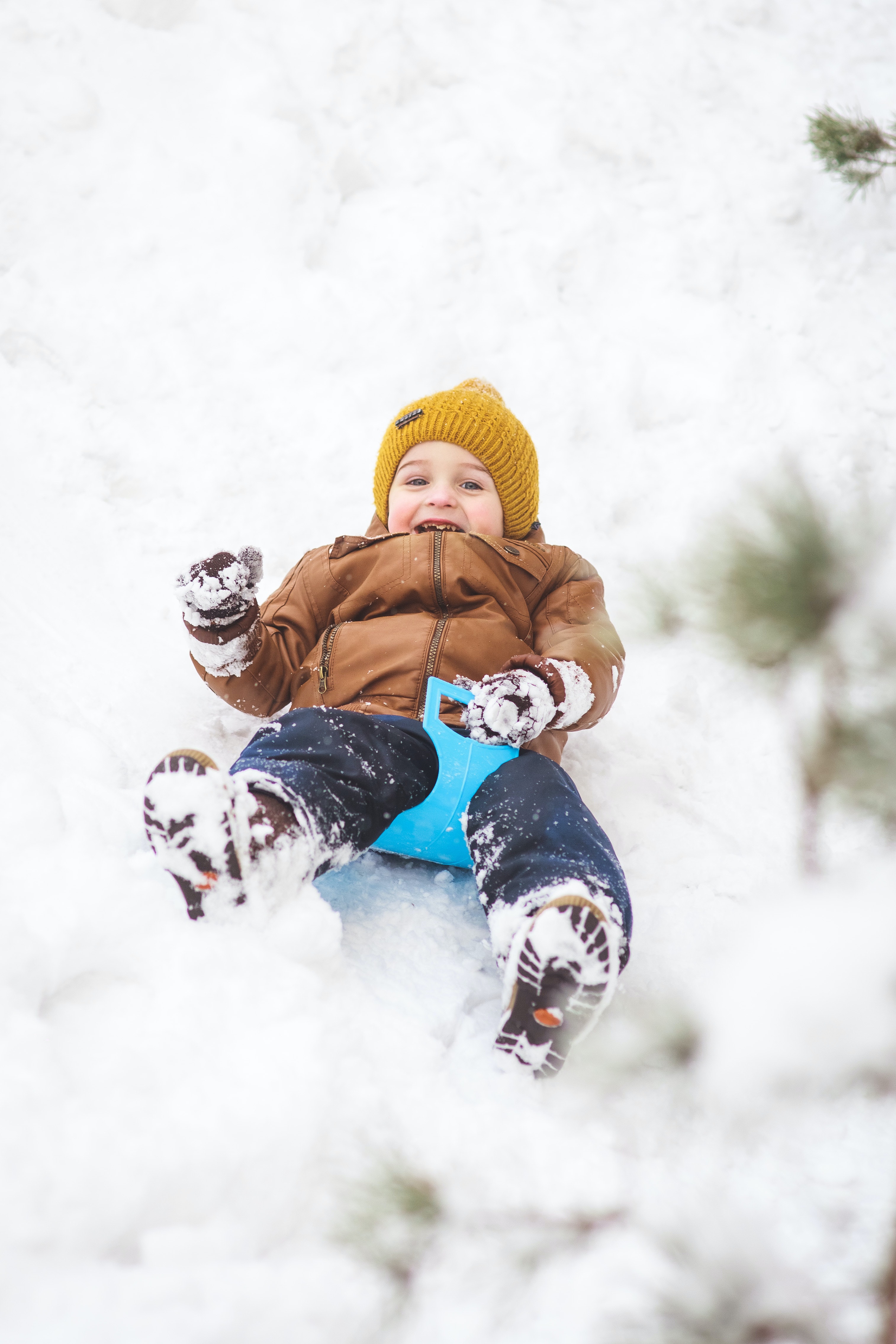 Child Tobogganing down a snowy hill in Red Deer, Alberta