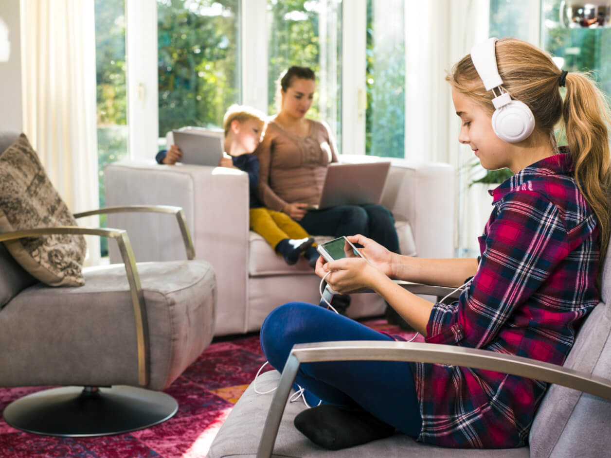 Family members together in their home using wireless devices.