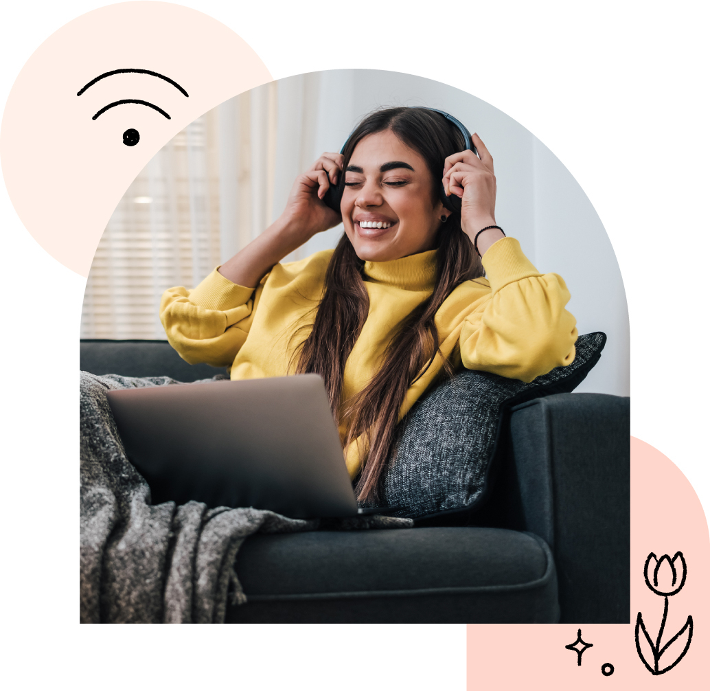 A woman sitting on a couch with laptop listening to music while using high-speed internet.