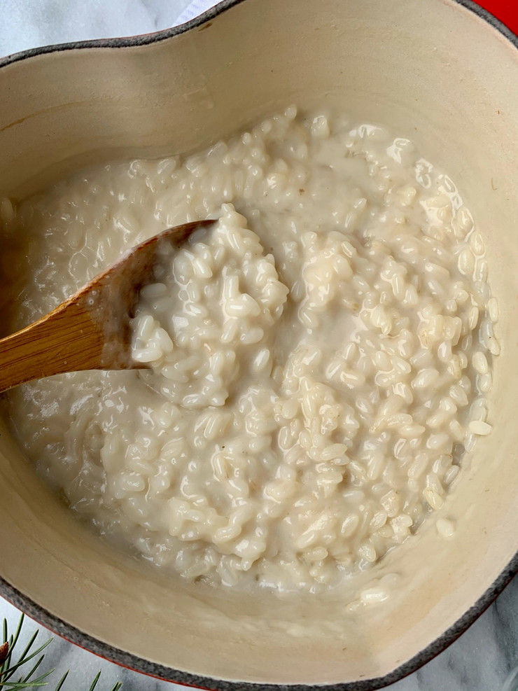 Cooked rice pudding in a heart-shaped Dutch oven with a wooden spoon