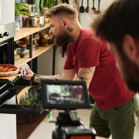 A photographer is filming a chef preparing delicious food.