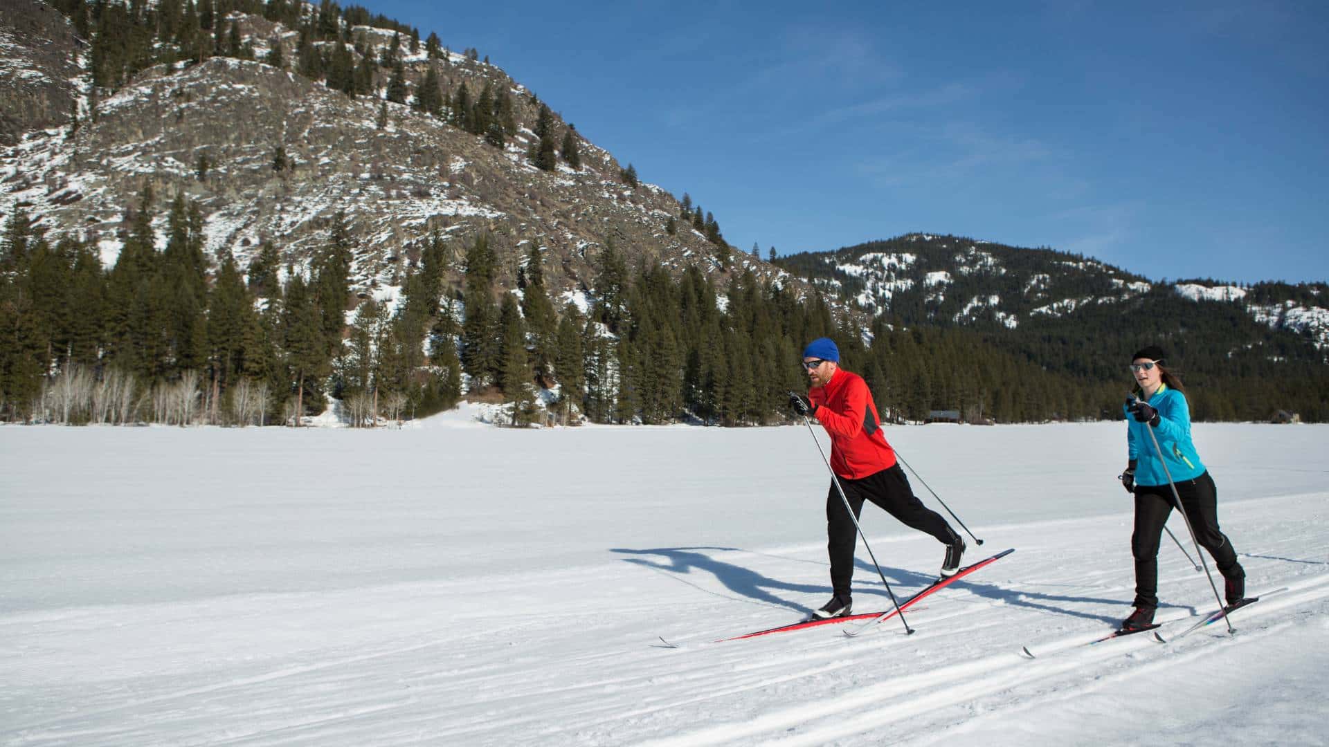 Two people skiing wearing base layers