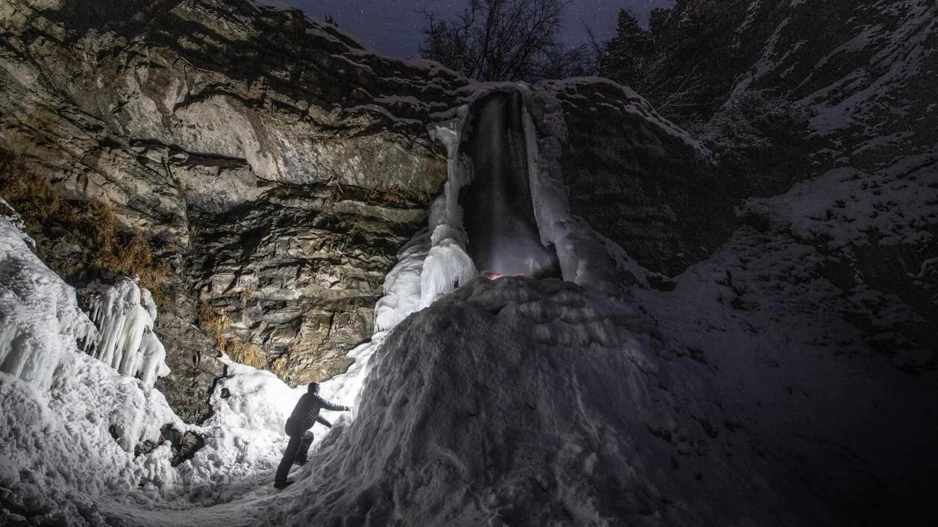 A person mountaineering wearing a headlamp