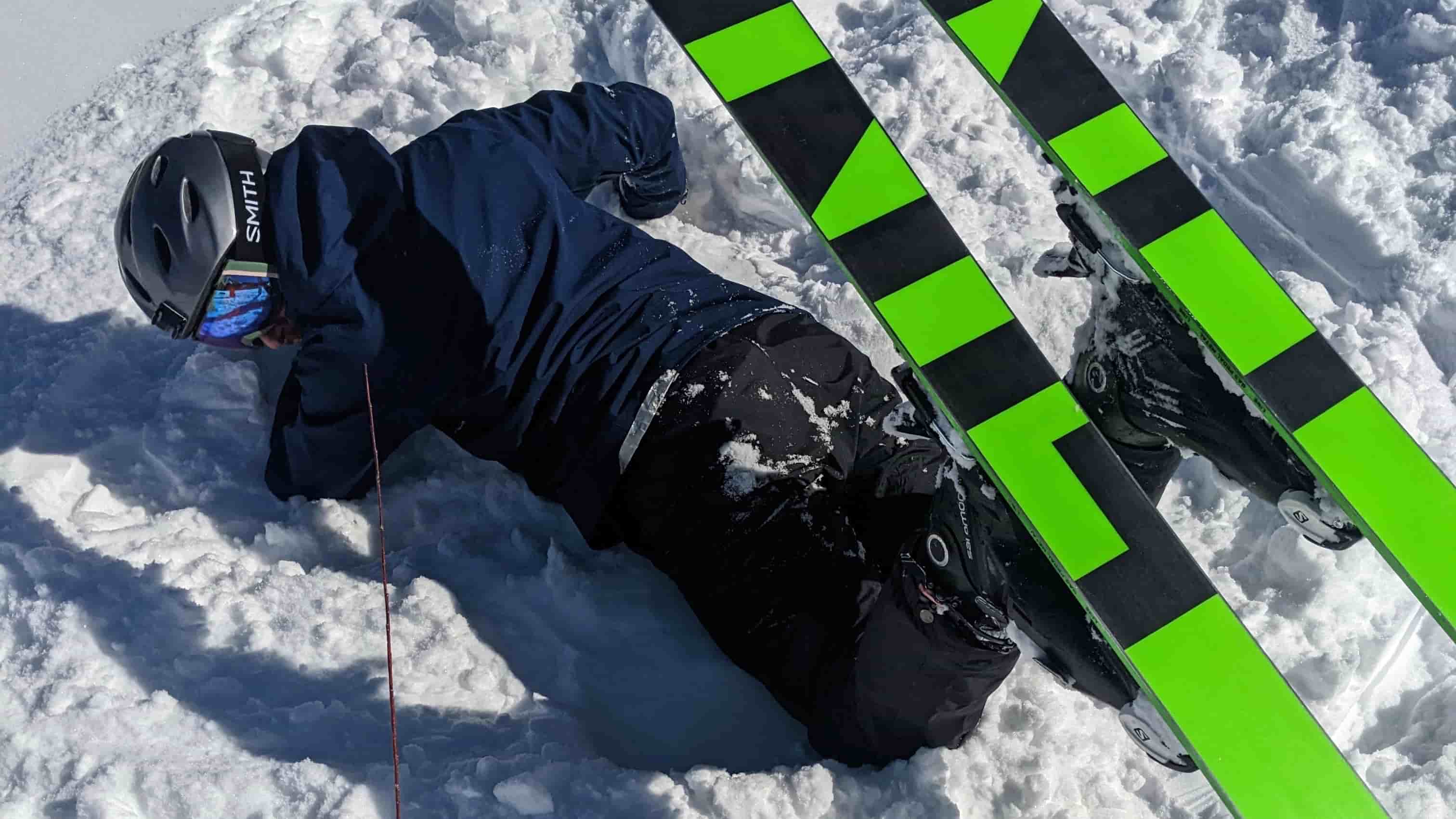 Person down in the snow wearing skis