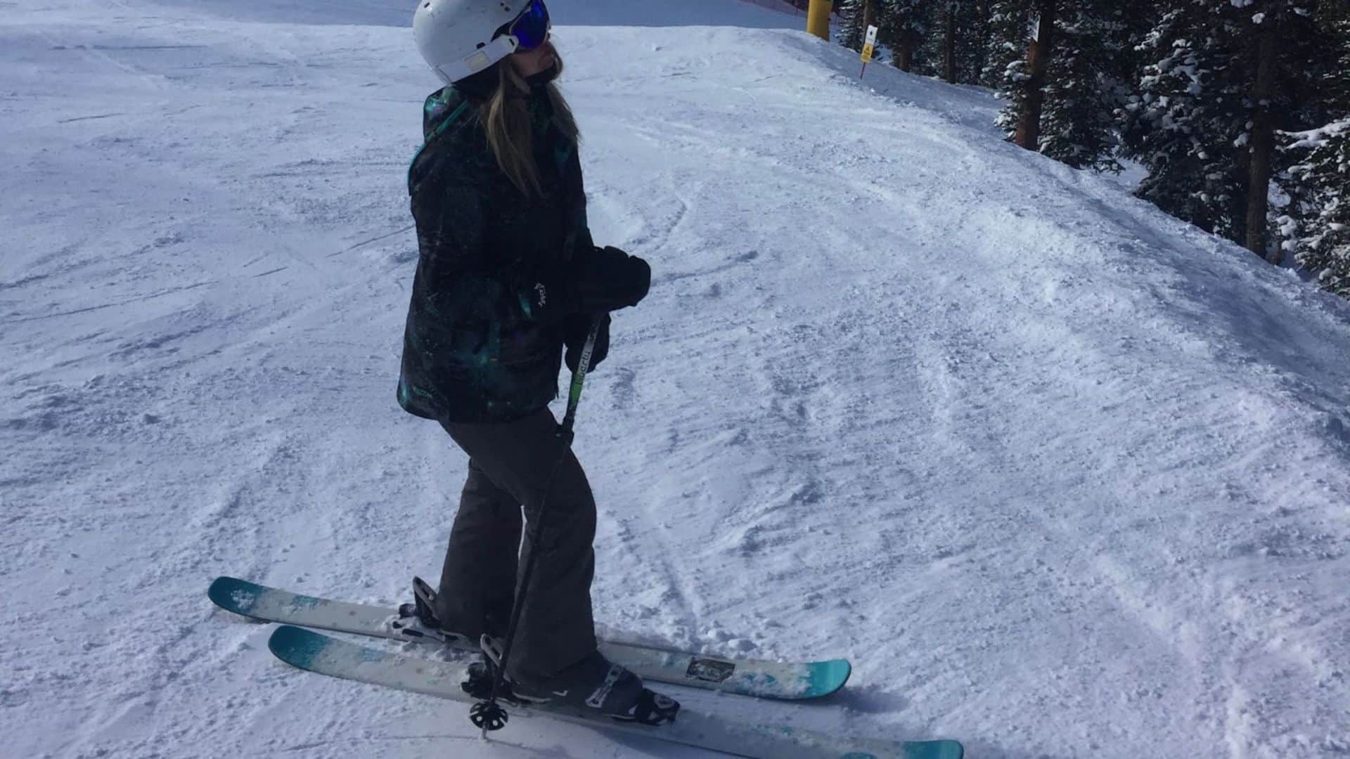 Woman wearing ski boots and holding skis