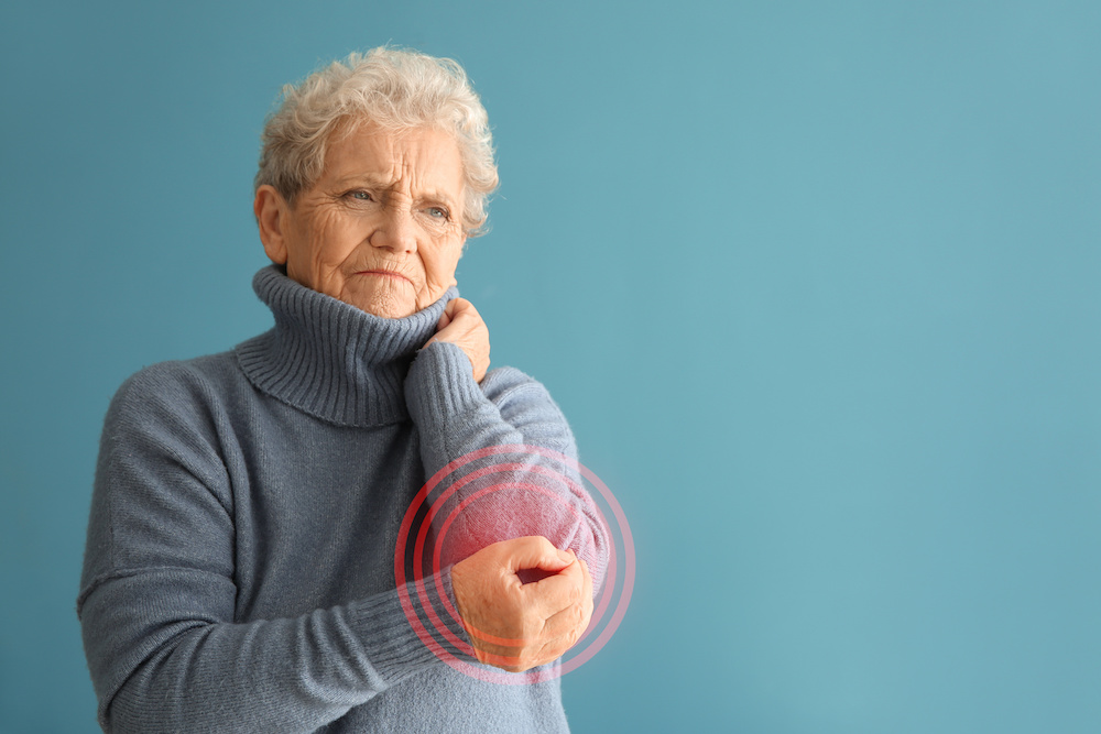 Senior woman holding elbow which is radiating pain signals