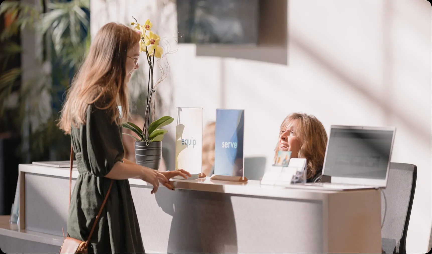 Two women talking at the front desk