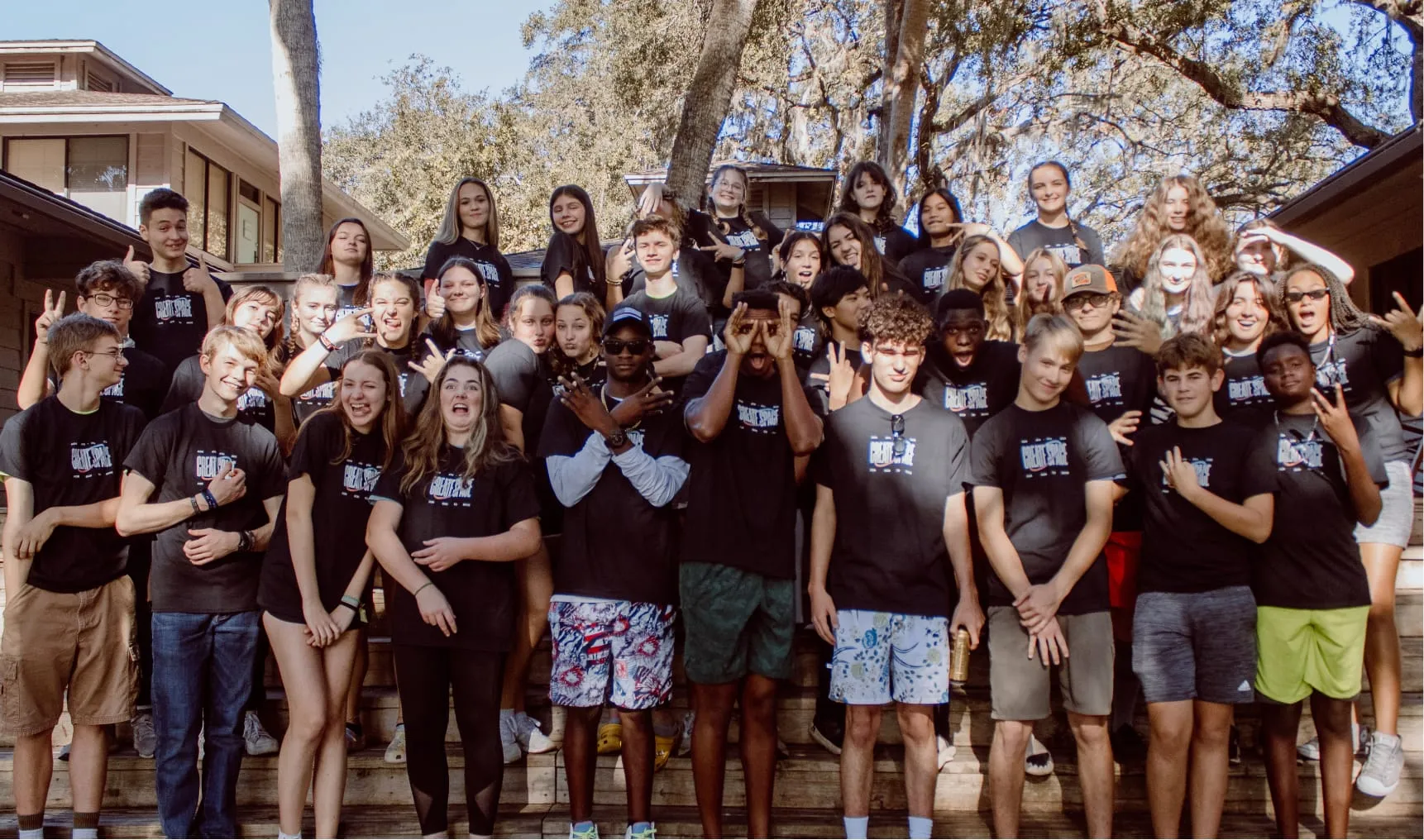 Group of students smiling, waving, and showing silly faces