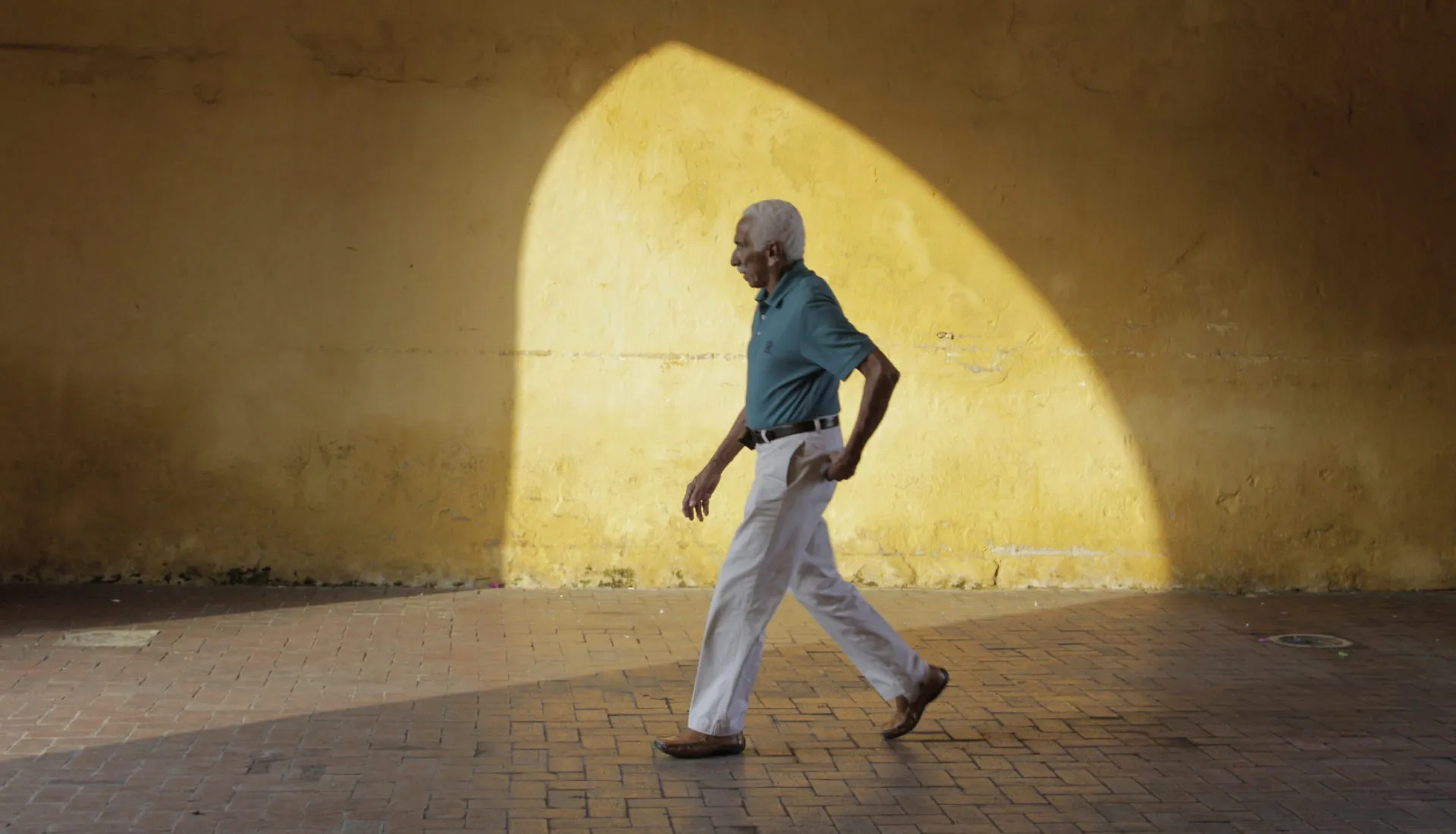 Man walking with sun appearing through archway before editing with VSCO filters