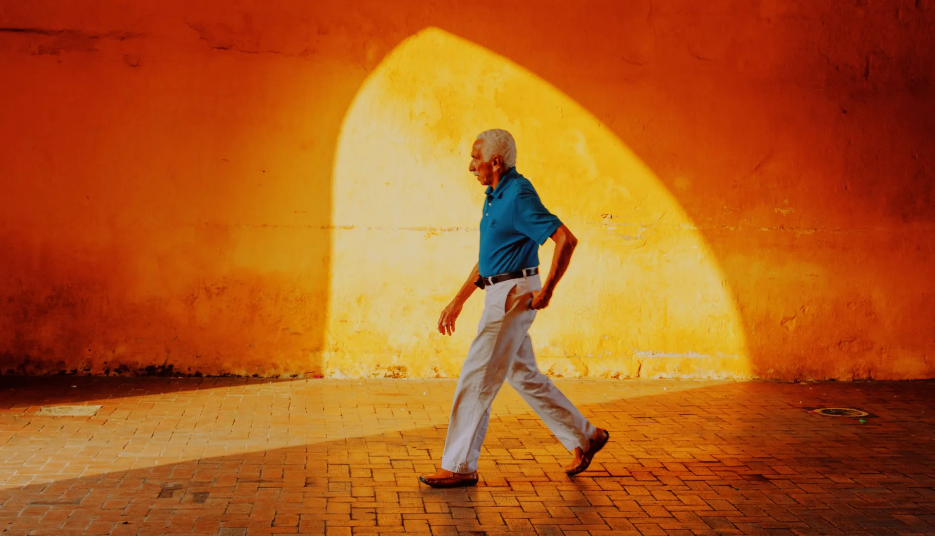 Man walking with sun appearing through archway edited with VSCO preset FR4X to look like Fuji Provia 400X film