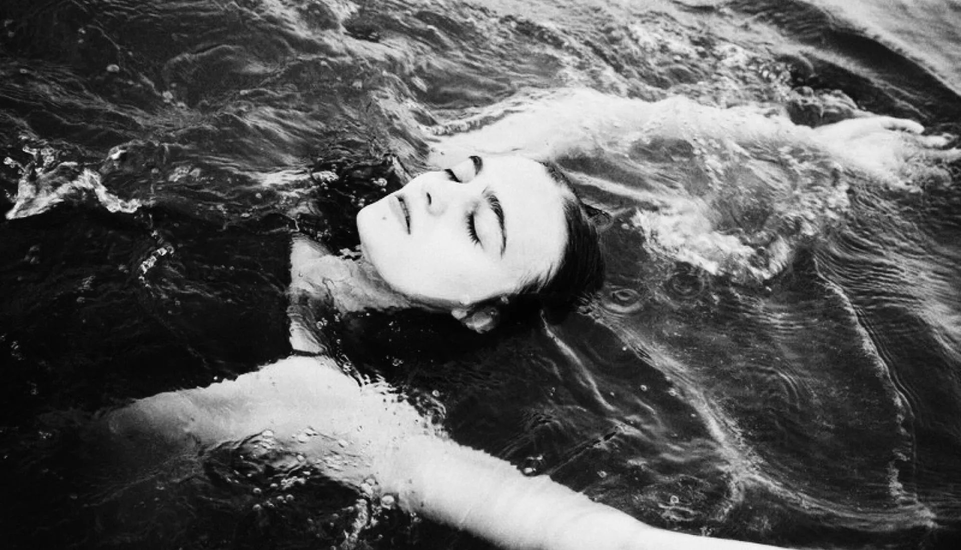 Woman floating on back in water edited with VSCO black and white preset B5