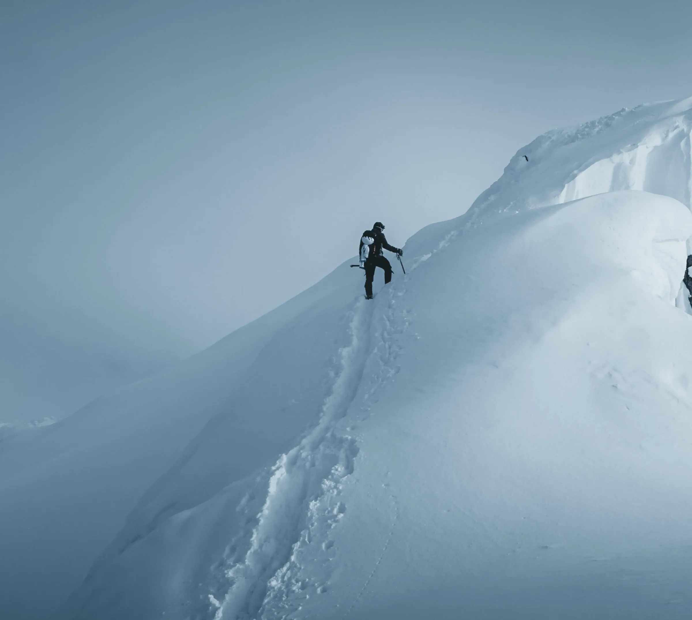 Hiker climbing snowy mountain peak after VSCO filter was added