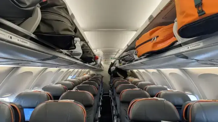 Full overhead bins on EasyJet flight, showing limited space for larger cabin bags and importance of early boarding