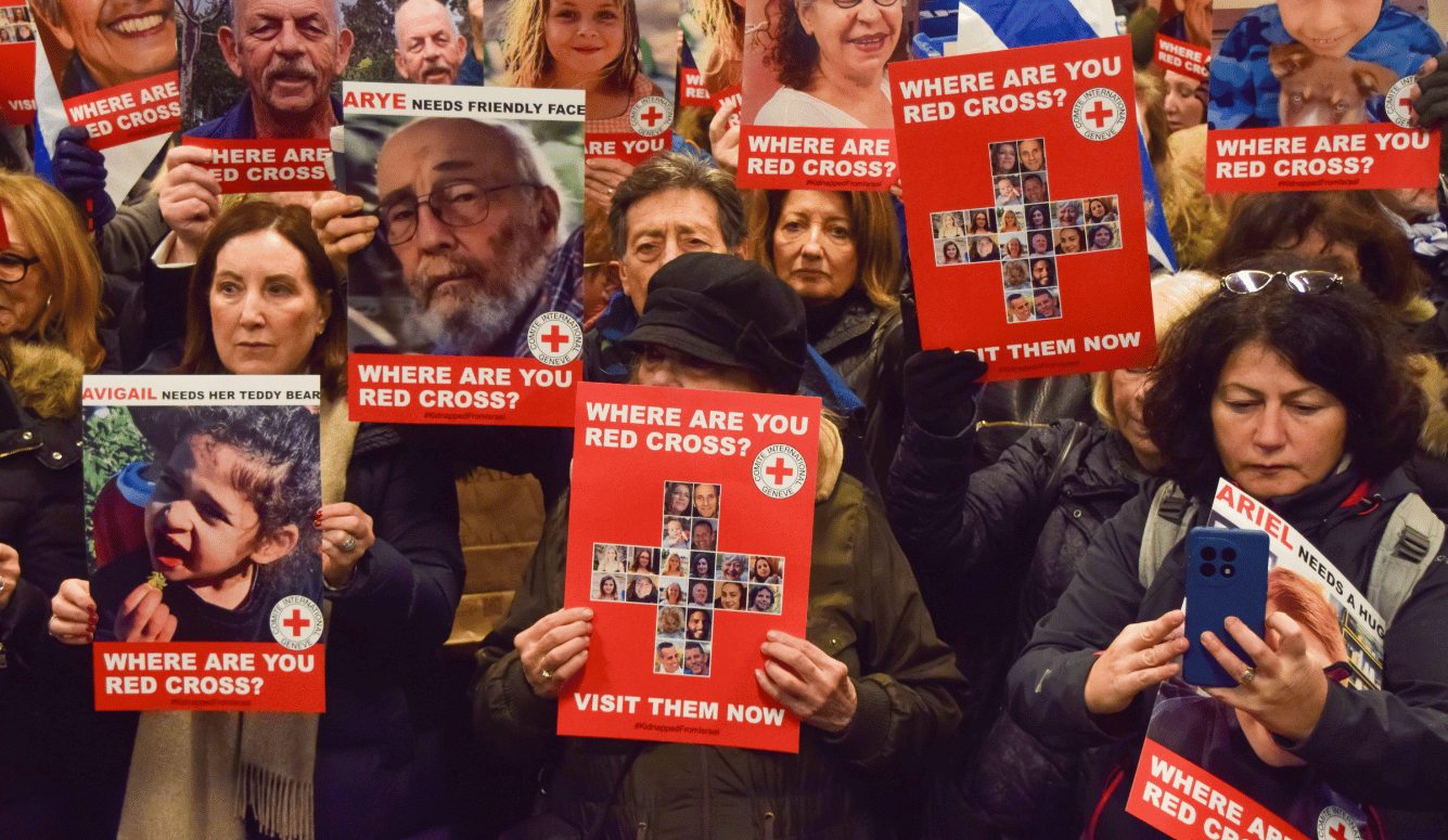 Pro-Israel protesters with red posters asking WHERE ARE YOU RED CROSS?