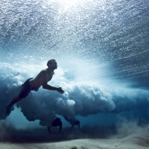 underwater_photo_of_swimmers_under_a_wave