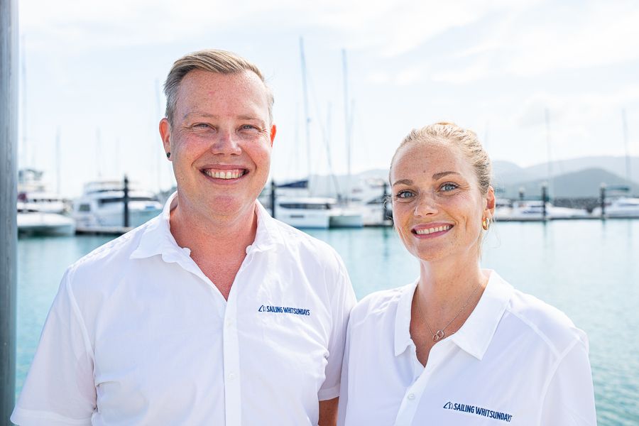 Two Travel Shop travel agents at the marina in white branded tshirts