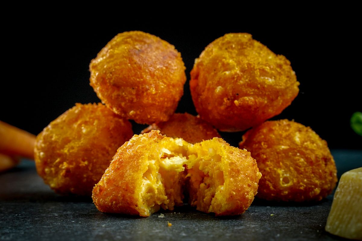 stack of cheese boulders with one pulled apart in front on black table