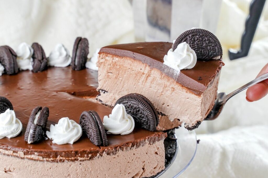 spatula with slice of cheesecake being lifted out of whole cake