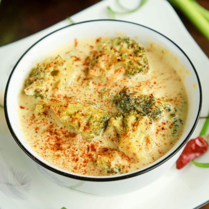 broccoli cheddar soup in white bowl with green rim