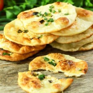 stack of green onion dumpling chips on wooden cutting board