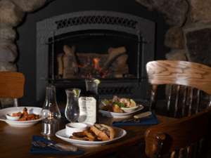 table of food next to a cozy fireplace