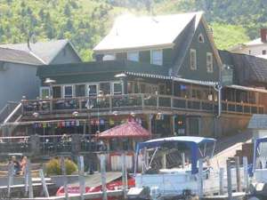 view of Christie's from the lake, showing boats, docks and outdoor decks for dining