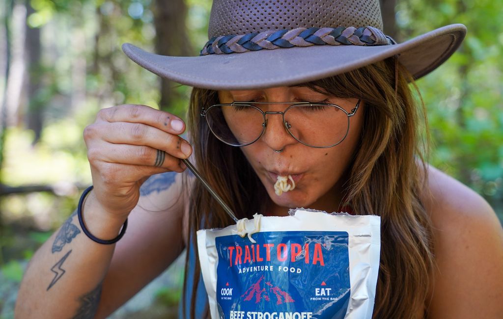 hiker eating a Trailtopia freeze dried meal