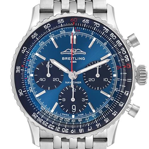 The Breitling Navitimer watch is shown from the front, highlighting its blue dial, chronograph subdials, and stainless steel bracelet.