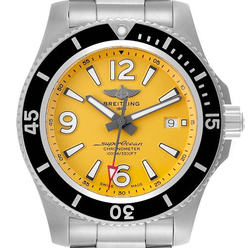 The Breitling Superocean watch is shown from the front, displaying its yellow dial, black bezel, and metal bracelet.