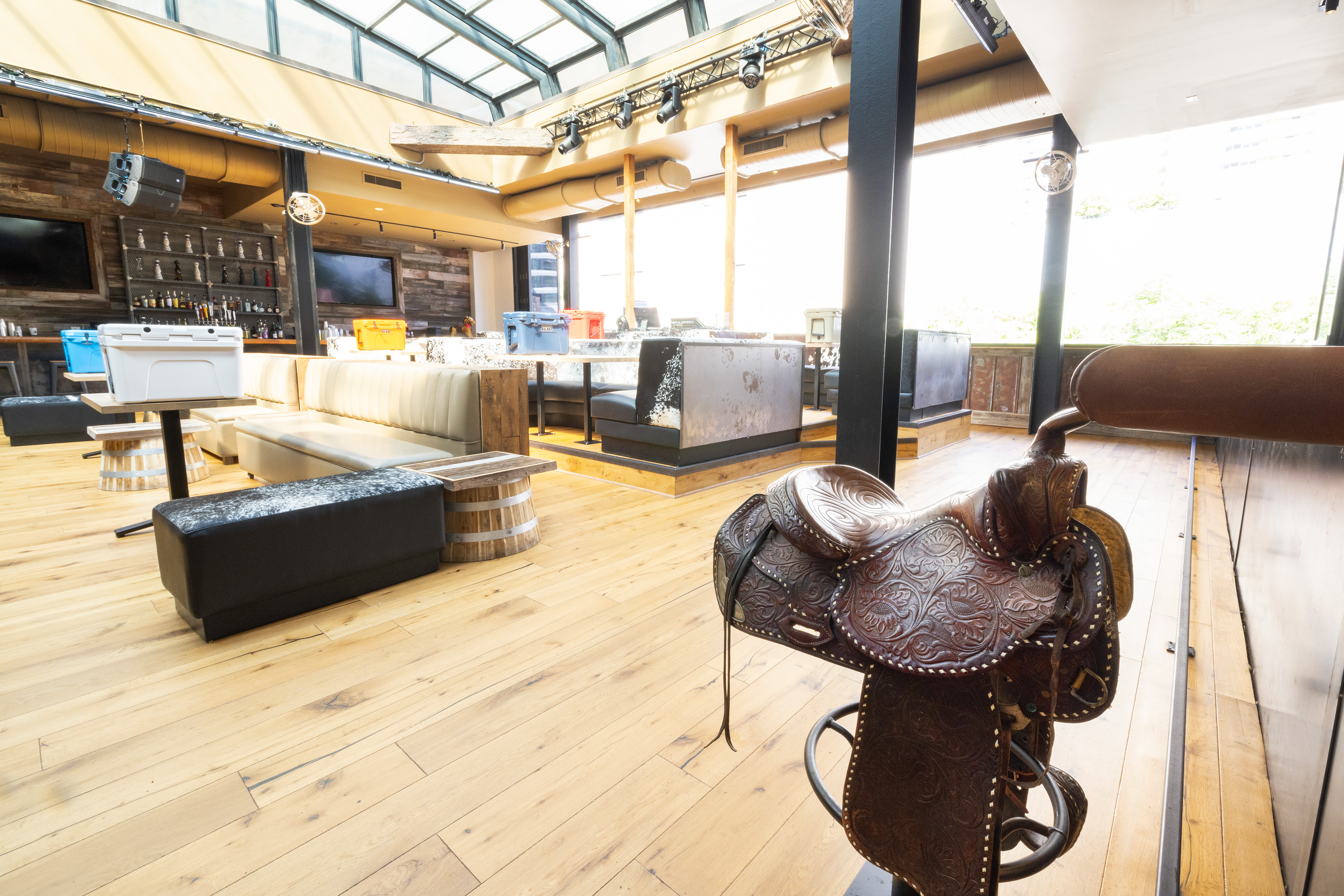 A bar with light wooden floors, and a rodeo horse.