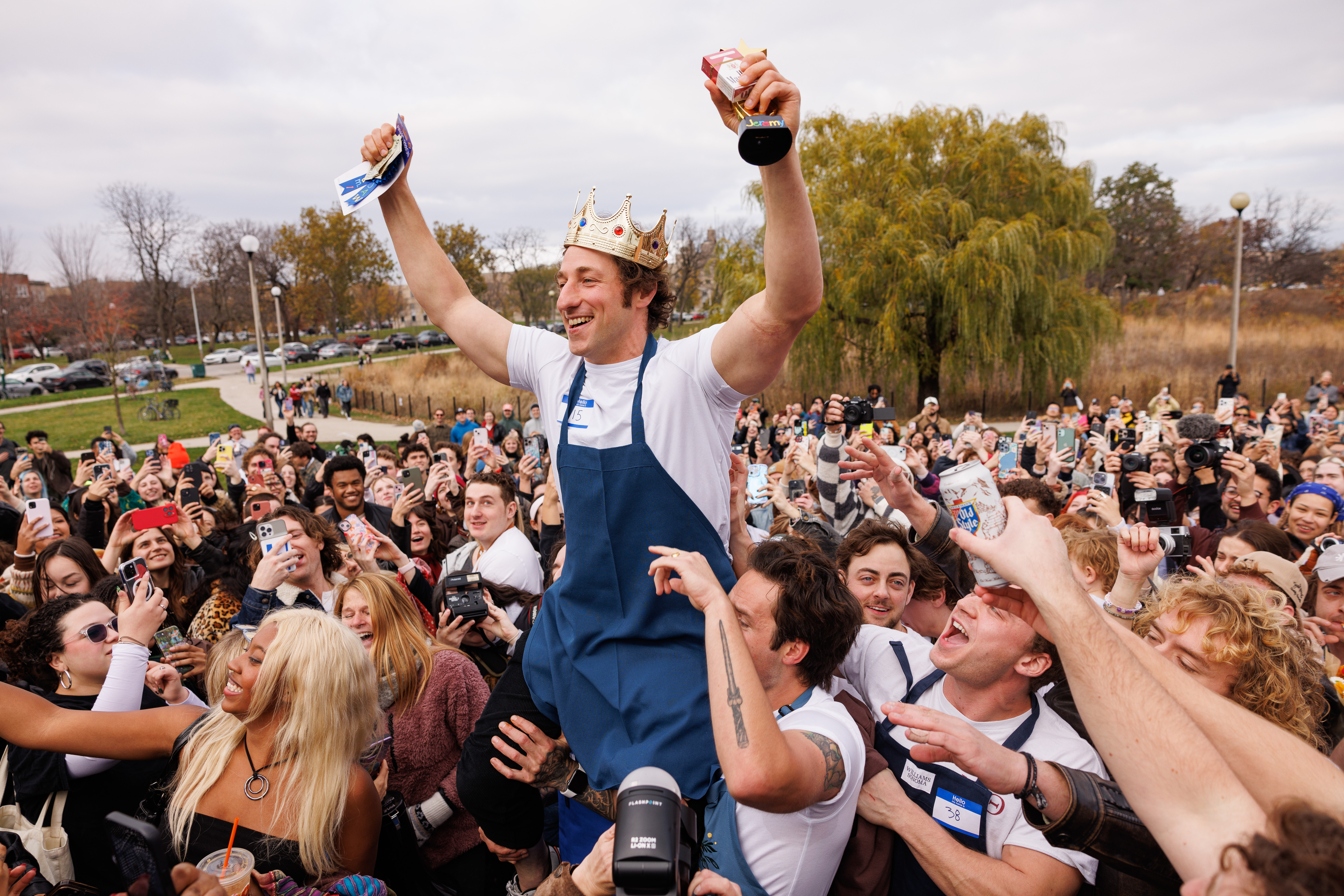 A man is hoisted in the air with a crown.