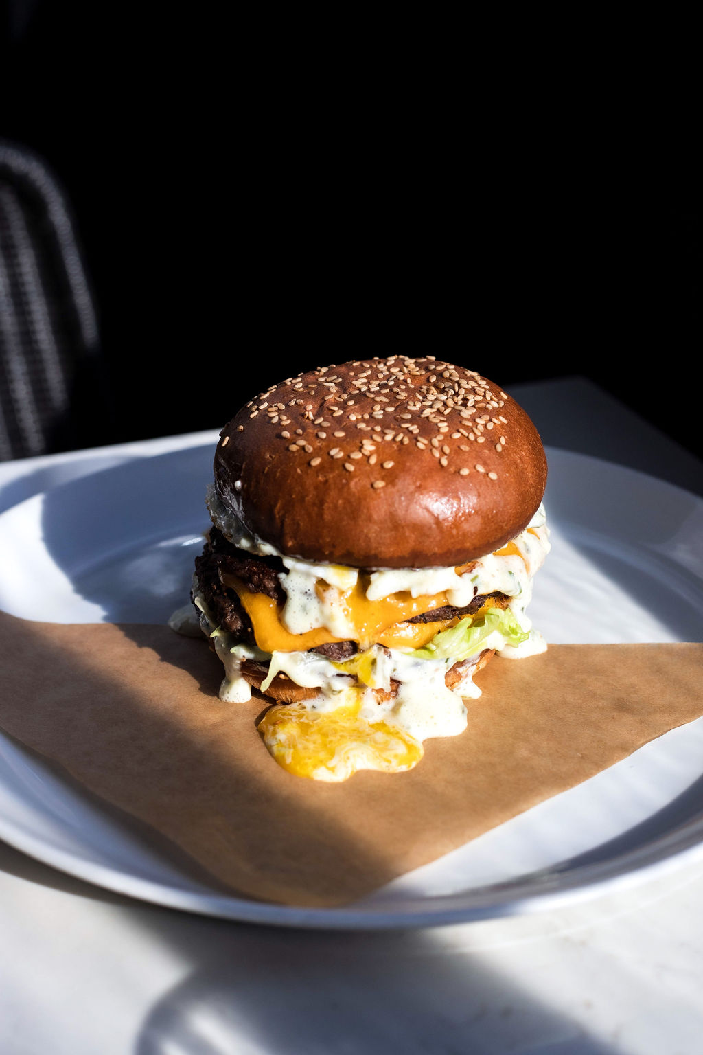 A burger set on a round white plate at Grey Ghost in Detroit, Michigan.