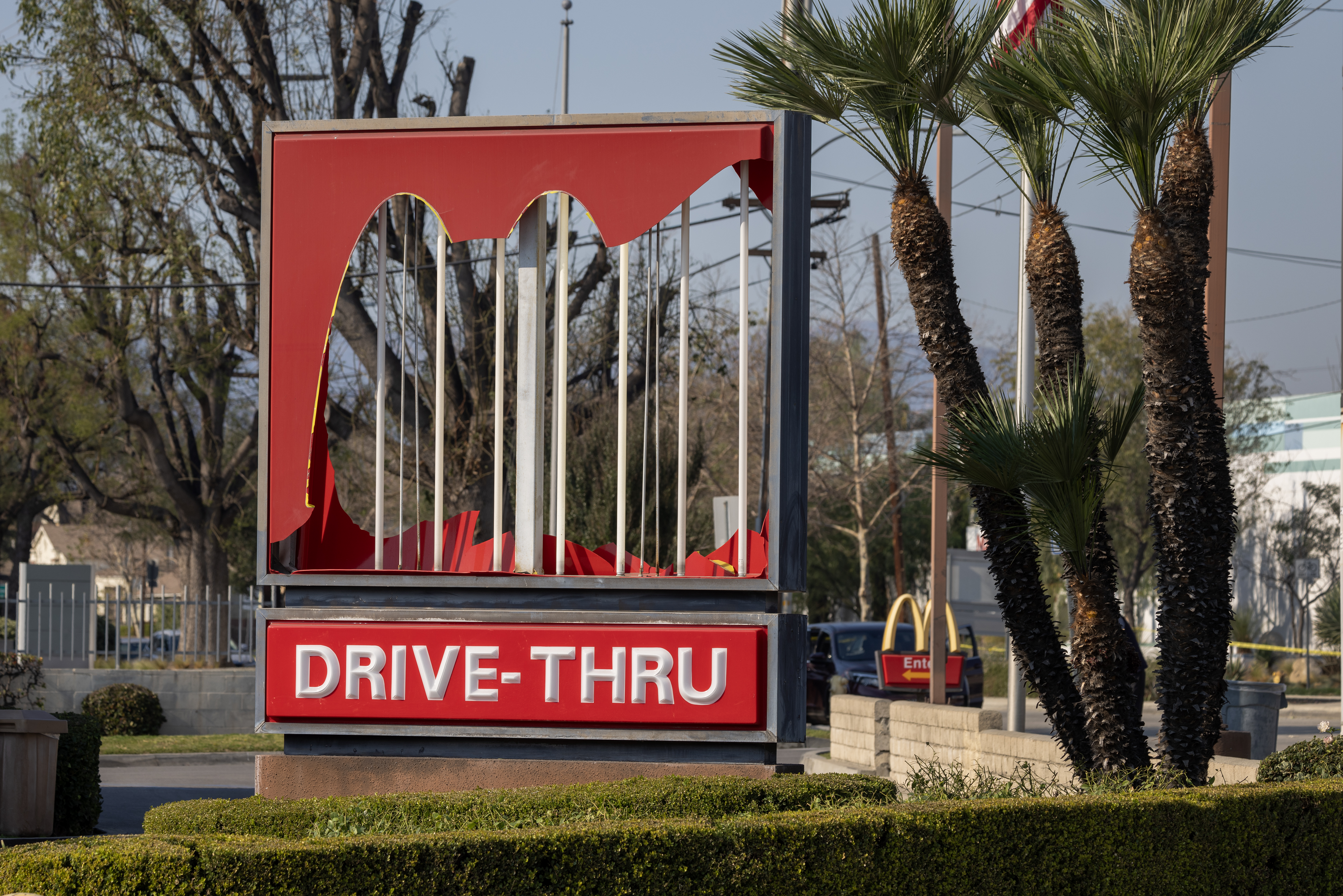 A McDonald’s restaurant sign is left damaged by high winds in the Eaton Fire on January 10, 2025 in Altadena, California.