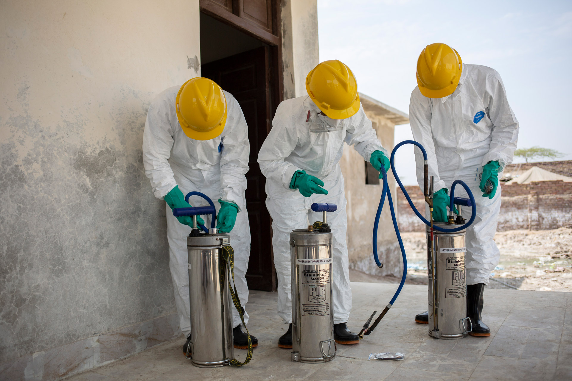 Men preparing indoor residual spraying equipment