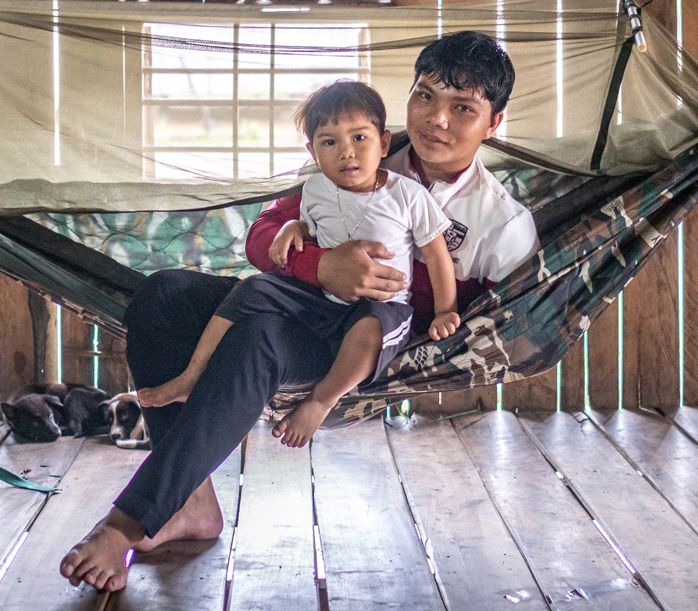 A father and son sitting on a mosquito net