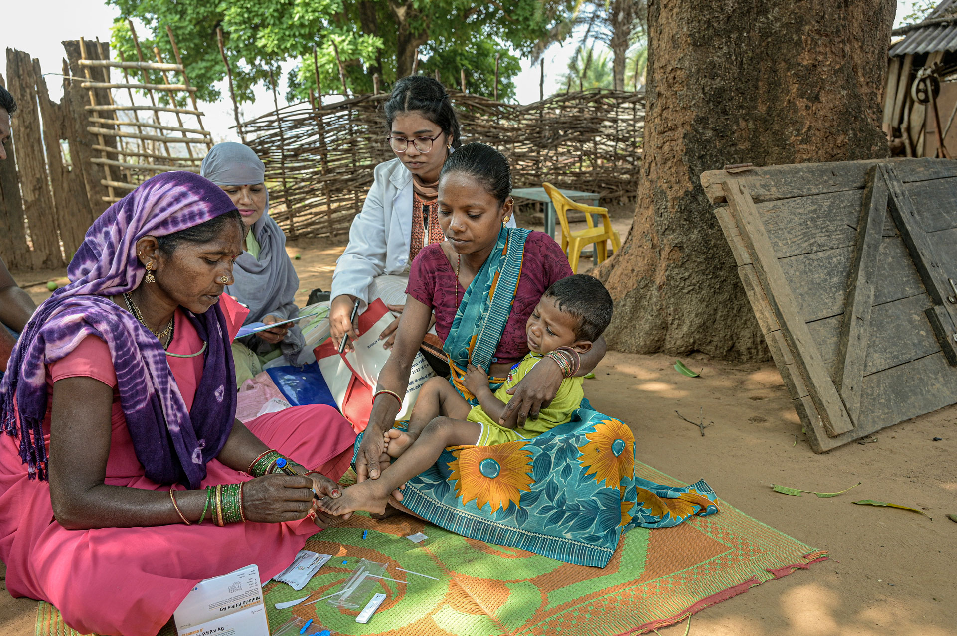 Health worker testing a baby for malaria