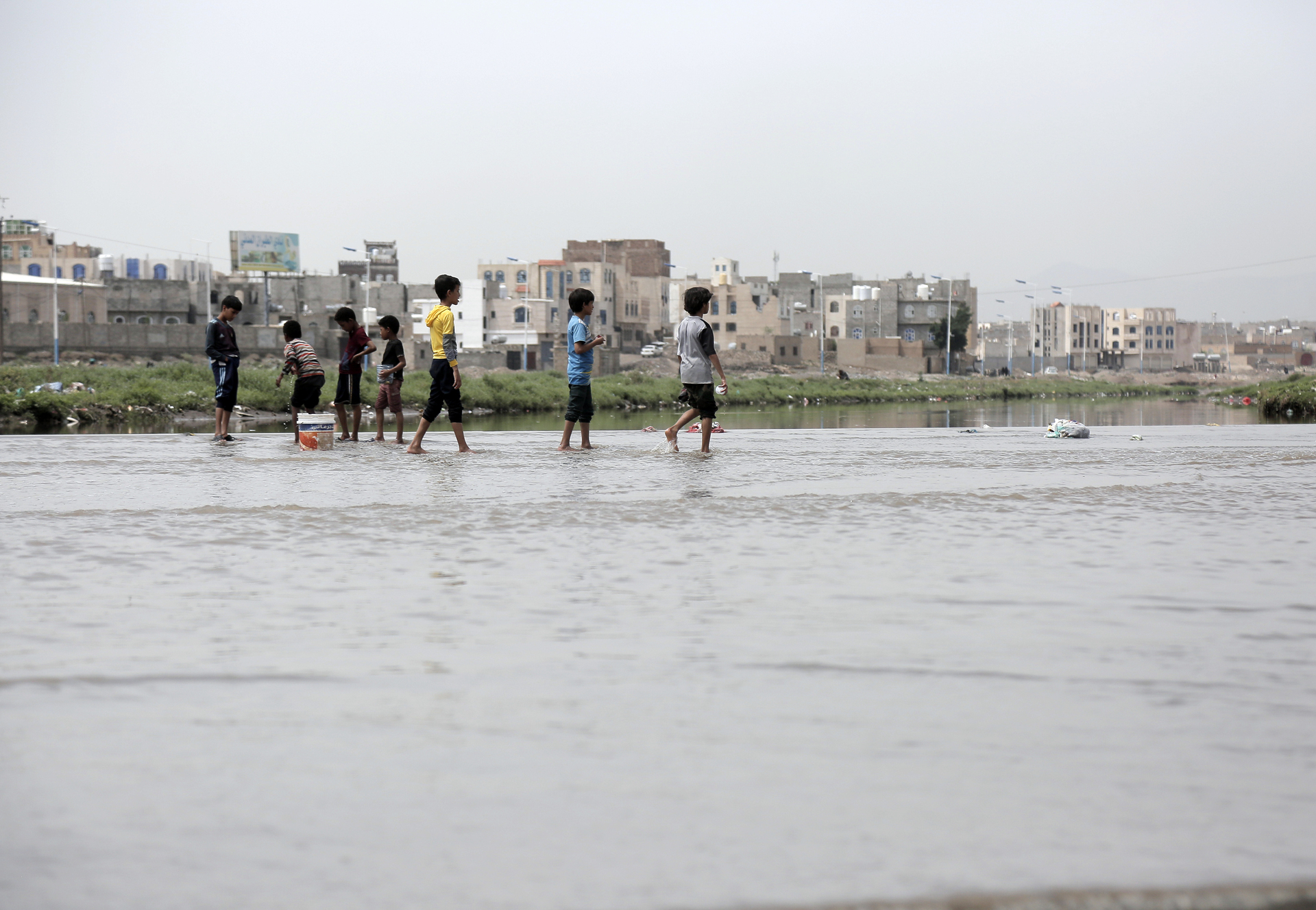 Children walking among flooded areas