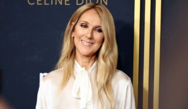 Celine Dion îmbrăcată într-o ținută albă elegantă, zâmbind fericită