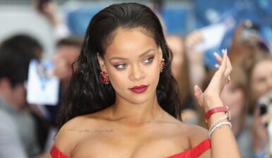 Rihanna îmbrăcată într-o rochie roșie sexy, asortată cu brățări strălucitoare și cercei