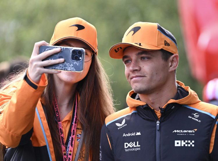 McLaren's British driver Lando Norris (R) poses for a 'selfie' as he walks in the paddock ahead of the Formula One Belgian Grand Prix at the Spa-Fr...