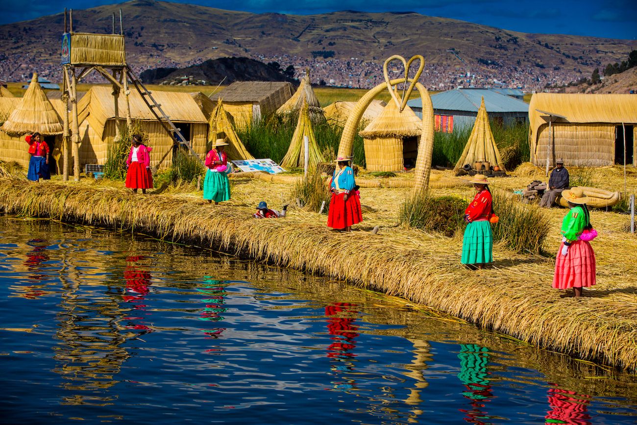 Local women waiting for visitors at the edge of the totora reeds island in the Uros Islands, Peru