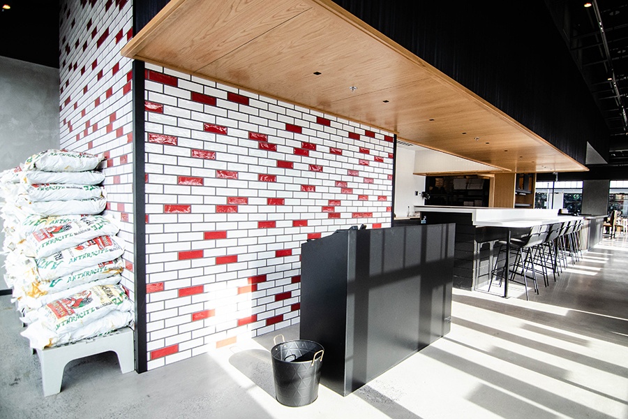 Interior of a restaurant features a red and white tiled wall.