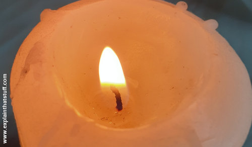 Flame, wick, and melted wax on top of a candle